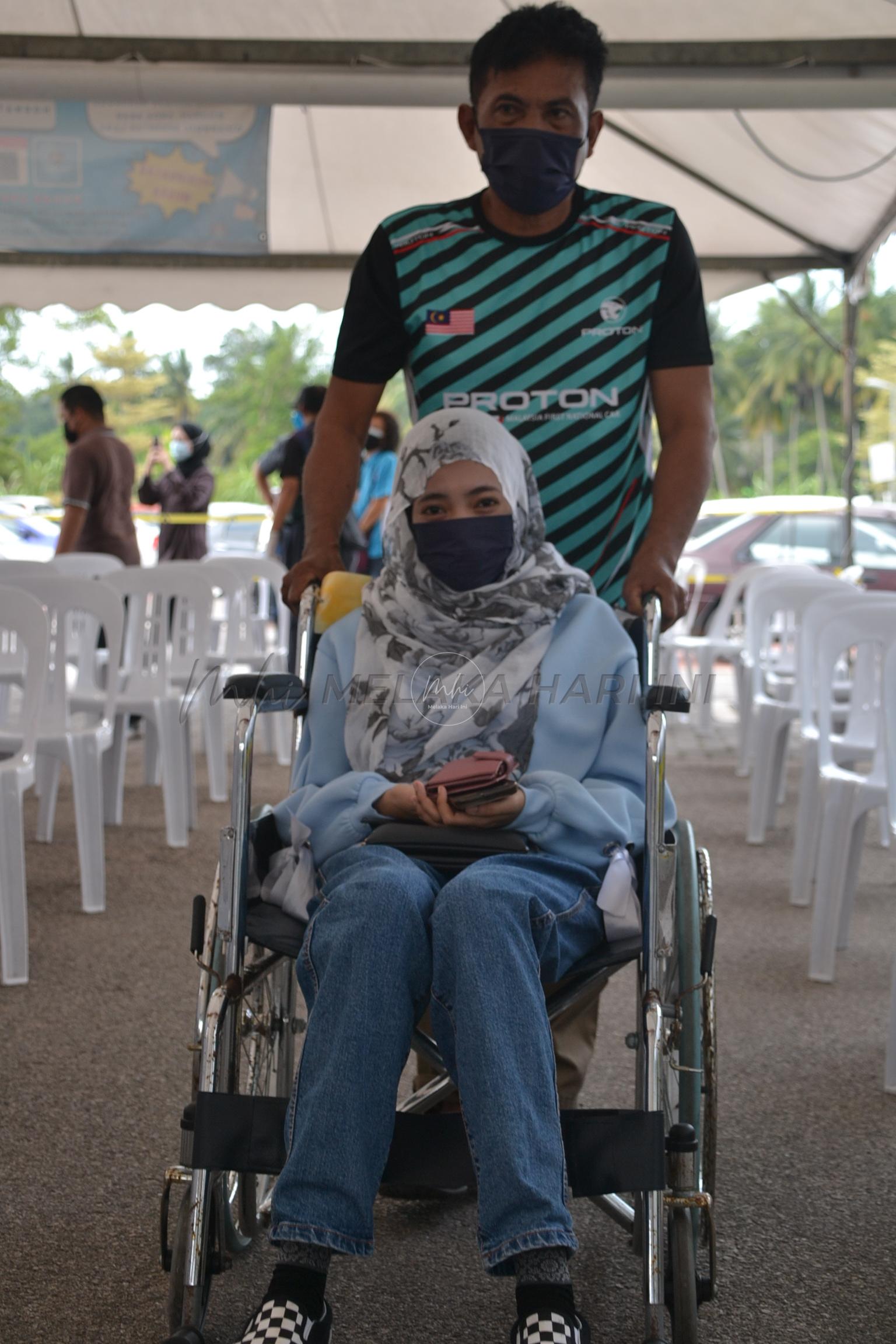 Gadis patah rusuk tetap hadir vaksin biarpun berkerusi roda