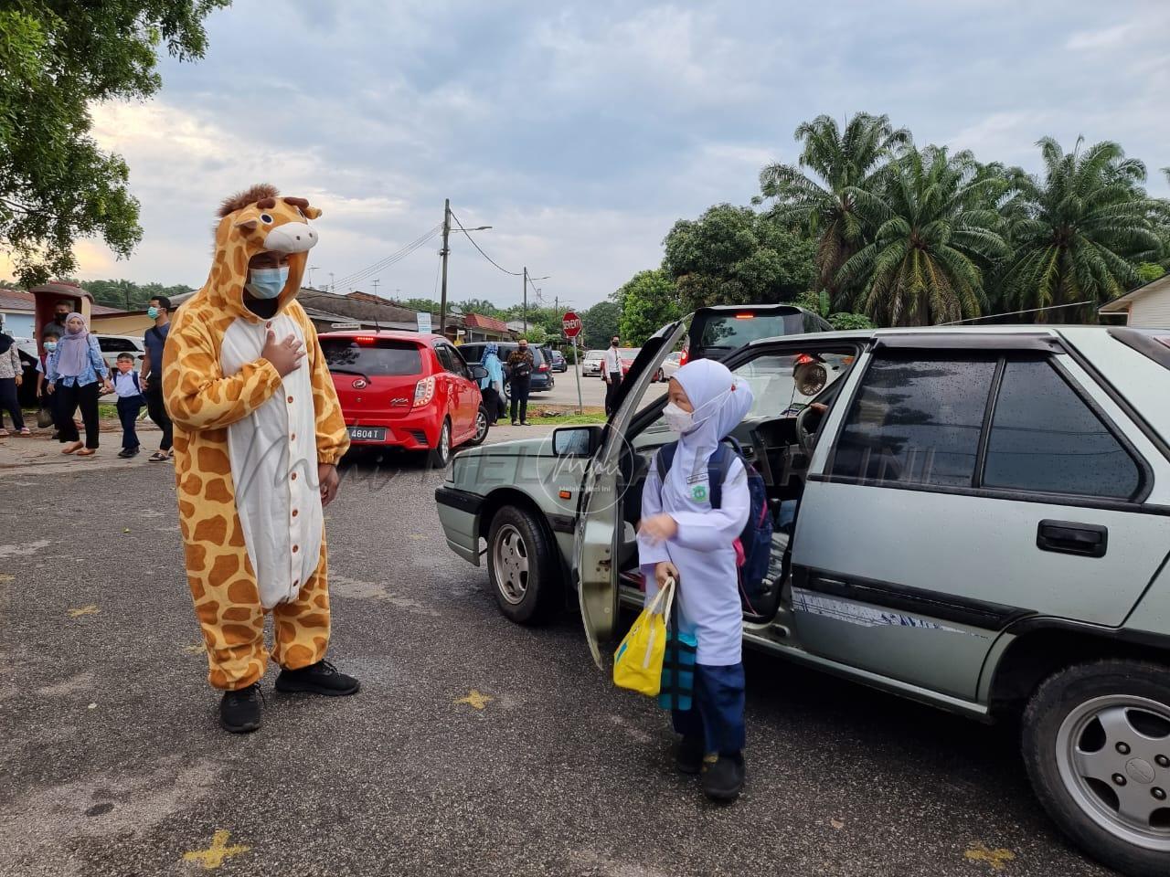 ‘Zirafah’ sambut murid depan pagar sekolah